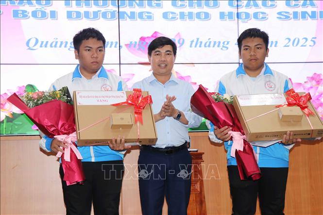 Giám đốc Ban Quản lý các công trình giao thông Quảng Nam Nguyễn Văn Thường tặng mỗi học sinh một máy tính phục vụ học tập. Ảnh: Đoàn Hữu Trung - TTXVN