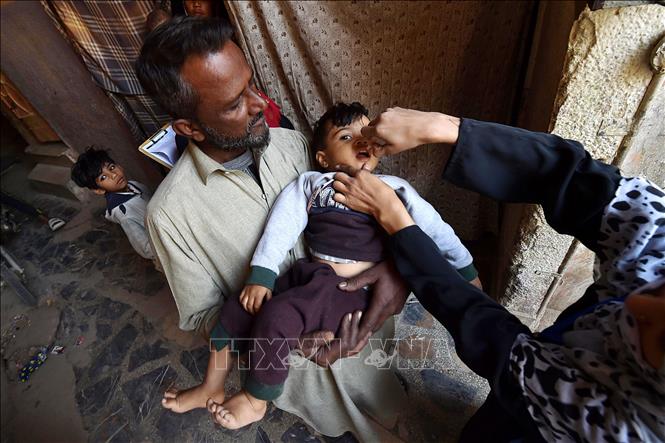Nhân viên y tế cho em nhỏ uống vaccine phòng bệnh bại liệt tại Karachi, Pakistan. Ảnh: THX/TTXVN