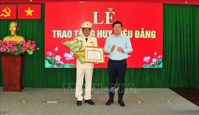 Bí thư Tỉnh ủy Đồng Tháp Lê Quốc Phong trao Huy hiệu 40 năm tuổi Đảng và tặng hoa chúc mừng Đại tá Nguyễn Văn Hiểu. Ảnh: TTXVN phát
