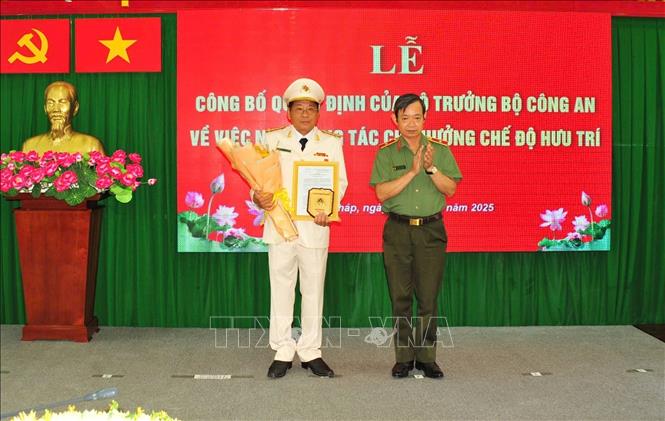 Thiếu tướng Huỳnh Văn Hải, Phó Cục trưởng Cục Tổ chức cán bộ trao Quyết định nghỉ chờ hưu cho Đại tá Nguyễn Văn Hiểu. Ảnh: TTXVN phát