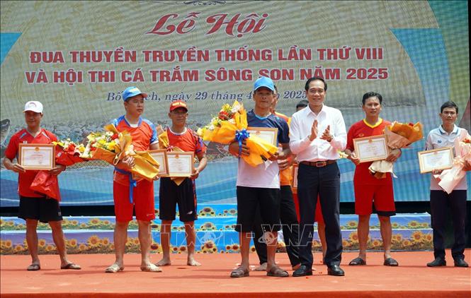 Ban Tổ chức trao thưởng cho đội đoạt giải Nhất bơi thuyền nam. Ảnh: TTXVN phát