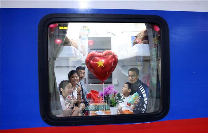 Tất cả du khách khi di chuyển bằng chuyến tàu SE1 tối 29/4 xuất phát tại Ga Hà Nội đều được Tổng công ty Đường sắt Việt Nam tặng quà kèm những lời chúc may mắn. Ảnh: Quốc Khánh - TTXVN