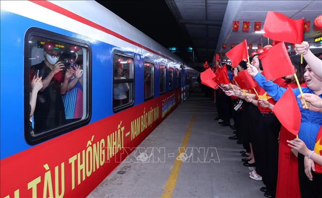 Lãnh đạo Tổng công ty Đường sắt Việt Nam vẫy cờ kèm những lời chúc may mắn đến những hành khách trên tàu SE1, tối 29/4 khi tàu lăn bánh rời Ga Hà Nội. Ảnh: Quốc Khánh - TTXVN