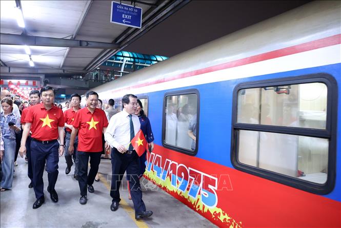 Lãnh đạo Tổng công ty Đường sắt Việt Nam đi tặng quà, chúc mừng hành khách trên chuyến tàu SE1 trước khi đoàn tàu rời Ga Hà Nội. Ảnh: Quốc Khánh - TTXVN