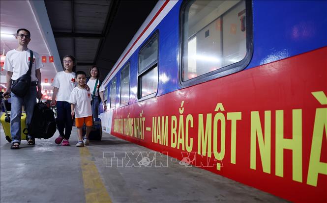 Một gia đình lên chuyến tàu Thống Nhất. Ảnh: Quốc Khánh - TTXVN