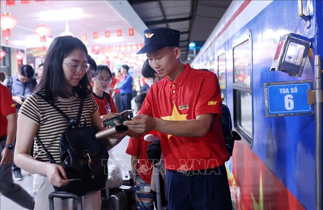 Nhân viên tàu SE1 hướng dẫn người dân lên tàu. Ảnh: Quốc Khánh - TTXVN
