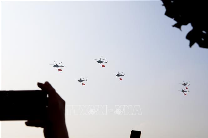 Biên đội máy bay trực thăng mang theo cờ Tổ quốc trình diễn trên bầu trời Thành phố Hồ Chí Minh. Ảnh: TTXVN
