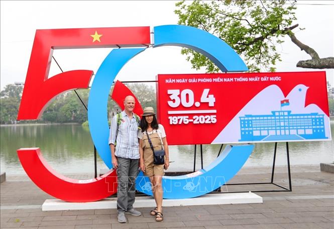 Du khách nước ngoài chụp ảnh lưu lại kỷ niệm sáng 30/4/2025. Ảnh: Khánh Hoà - TTXVN