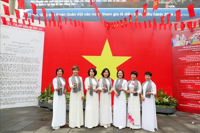 Người dân check-in với cờ Tổ quốc tại trụ sở Thông tấn xã Việt Nam. Ảnh: Khánh Hoà - TTXVN