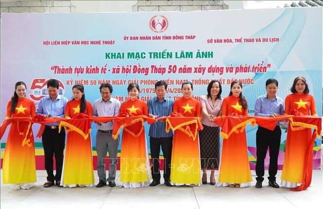 Đại biểu thực hiện nghi thức cắt băng khai mạc Triển lãm ảnh “Thành tựu kinh tế - xã hội Đồng Tháp 50 năm xây dựng và phát triển”. Ảnh: Nhựt An - TTXVN