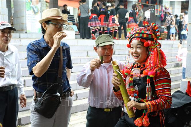 Du khách thưởng thức rượu nếp của dân tộc Hà Nhì tại chợ phiên vùng cao. Ảnh: Lê Đông – TTXVN