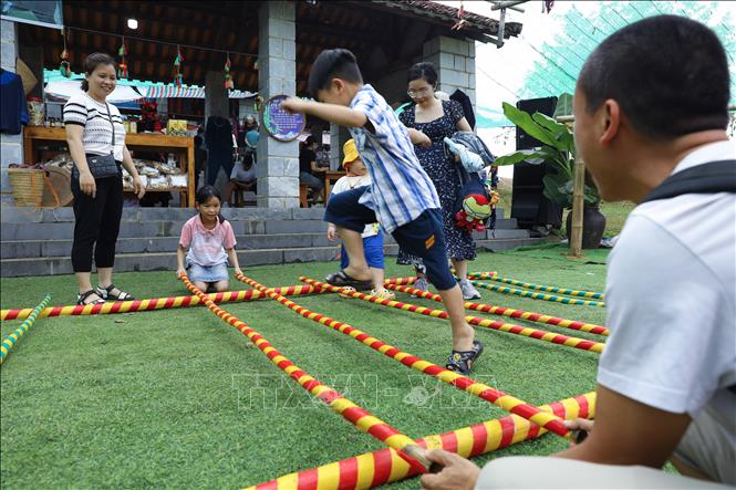 Thiếu nhi trải nghiệm trò chơi nhảy sạp của đồng bào dân tộc. Ảnh: Lê Đông – TTXVN