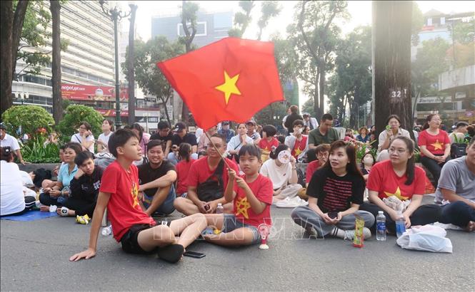 Children are excited to wait for the parade. VNA Photo 