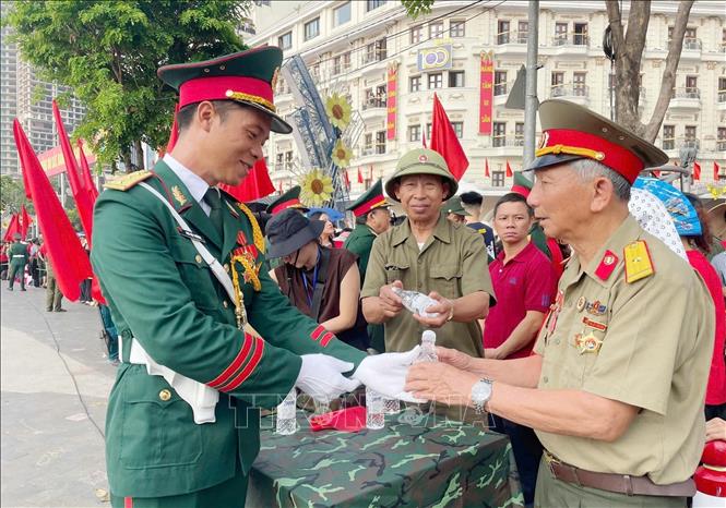 Soldiers give drinks and cookies to people taking part in the celebration. VNA Photo