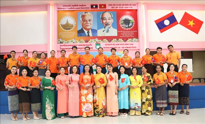 Thầy, cô Việt Nam và Lào ở Trường song ngữ Lào-Việt Nam Nguyễn Du tham dự buổi xem tường thuật trực tiếp Lễ kỷ niệm 50 năm Giải phóng miền Nam, thống nhất đất nước. Ảnh: Xuân Tú - PV TTXVN tại Lào