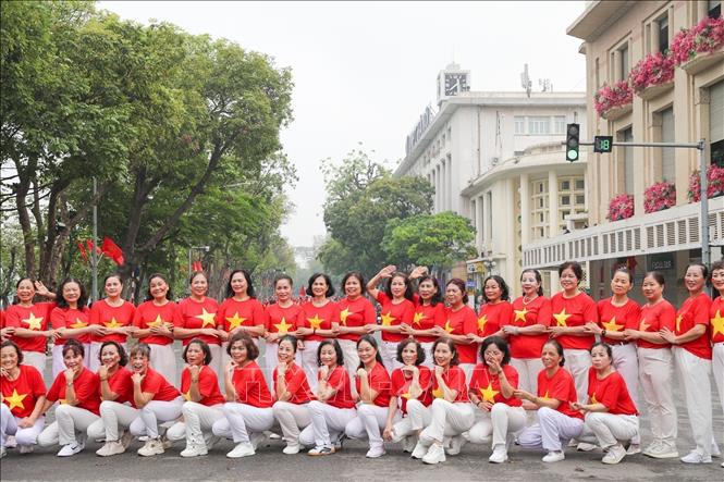 Many people wear clothes in red with yellow star to express their emotions of pride and joy of the event. VNA Photo