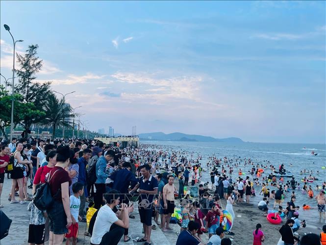 Trời nắng nóng nhưng không quá gay gắt tạo điều kiện cho người dân đến tắm biển Cửa Lò. Ảnh: Bích Huệ - TTXVN