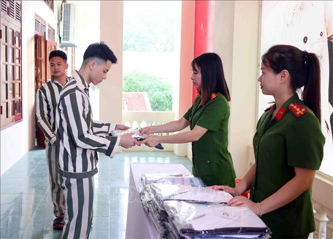 Cán bộ Trại giam Ninh Khánh (Ninh Bình) cấp phát quần áo cho người được đặc xá. Ảnh: Phạm Kiên - TTXVN