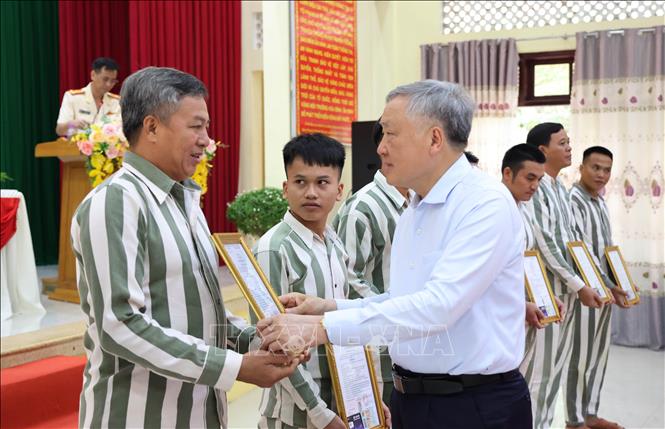 Niềm xúc động của một phạm nhân khi nhận Giấy chứng nhận đặc xá do Phó Thủ trướng Thường trực Nguyễn Hòa Bình trao. Ảnh: Tiên Minh - TTXVN