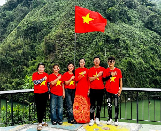 Người dân vùng cao Hà Giang mang trang phục cờ đỏ sao vàng chụp ảnh mừng đại lễ thống nhất đất nước. Ảnh: Đức Thọ - TTXVN