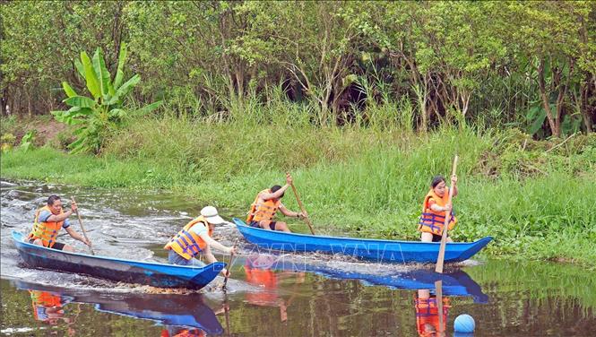 Du khách tham gia phần thi chèo xuồng ba lá. Ảnh: Huỳnh Anh - TTXVN