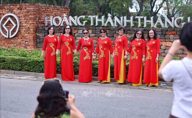 Du khách tham quan Di sản thế giới Hoàng thành Thăng Long, chụp ảnh lưu niệm trong ngày Quốc tế Lao động 1/5. Ảnh: Thanh Tùng - TTXVN 