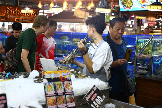 Người dân mua thực phẩm tại một khu chợ ở Bangkok, Thái Lan. Ảnh: THX/TTXVN