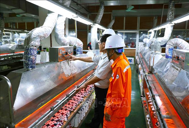 Công nhân Điện lực Thanh Hoá kiểm tra thiết bị điện trong nhà xưởng sản xuất của Công ty CP dụng cụ thể thao DELTA, huyện Hoằng Hoá, tỉnh Thanh Hoá. Ảnh: Vũ Sinh - TTXVN