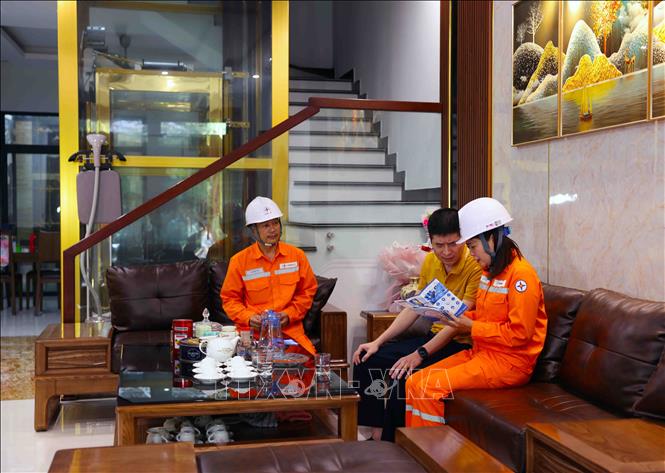 Công nhân Điện lực Thanh Hoá đến tận nhà tuyên truyền, hướng dẫn người dân sử dụng điện an toàn, tiết kiệm và hiệu quả ở thành phố Thanh Hoá, tỉnh Thanh Hoá. Ảnh: Vũ Sinh - TTXVN
