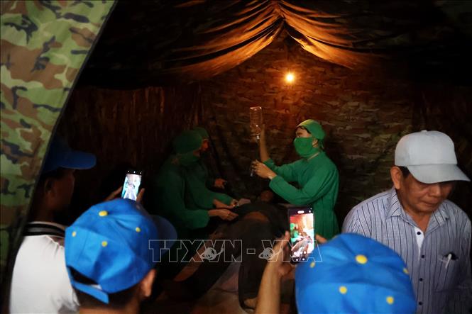 Khách tham quan phòng cứu thương ở địa đạo Củ Chi. Ảnh: Hồng Đạt - TTXVN
