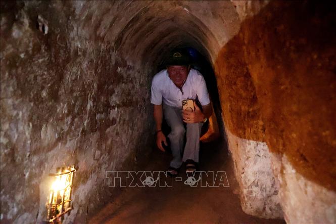 Khách tham quan trải nghiệm không gian đường hầm trong địa đạo Củ Chi. Ảnh: Hồng Đạt - TTXVN
