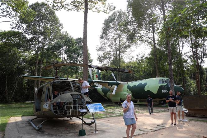 Khách quốc tế tham quan, tìm hiểu các loại máy bay chiến đấu đã tàn phá vùng đất thép Củ Chi. Ảnh: Hồng Đạt - TTXVN
