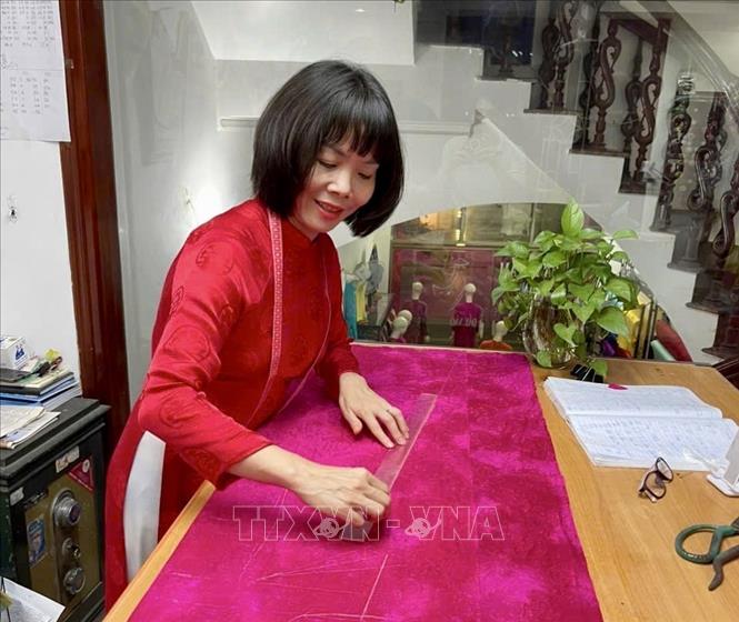 Sự kết hợp giữa tinh hoa may mặc và biểu tượng thành phố trên nền lụa Vạn Phúc chính là minh chứng rõ nét cho tâm huyết và niềm tự hào của chị Tươi dành cho vùng đất Cảng. Ảnh: Minh Huệ - TTXVN