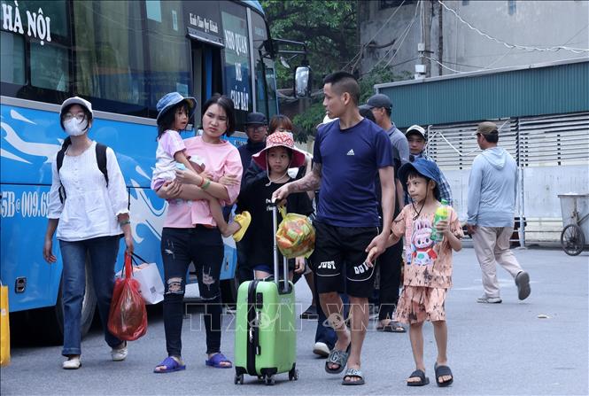 Người dân lỉnh kỉnh đồ đạc về tới bến xe Giáp Bát. Ảnh: Quốc Khánh - TTXVN