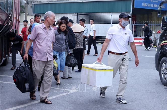 Người dân lỉnh kỉnh đồ đạc quay trở lại Thủ đô tại bến xe Giáp Bát. Ảnh: Quốc Khánh - TTXVN