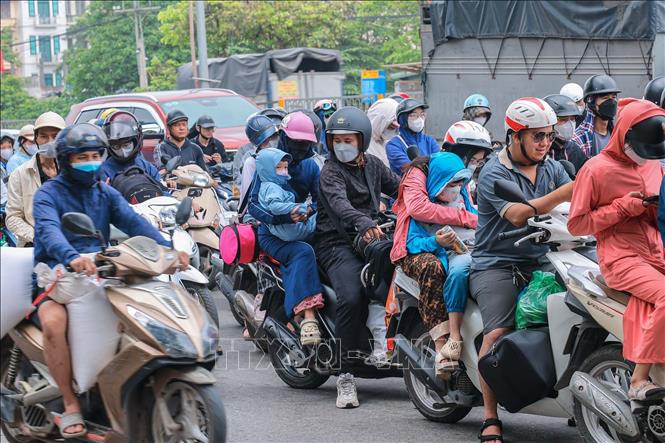 Nhiều gia đình chở theo trẻ nhỏ quay lại Thủ đô trong sáng 4/5. Ảnh: Hoàng Hiếu - TTXVN