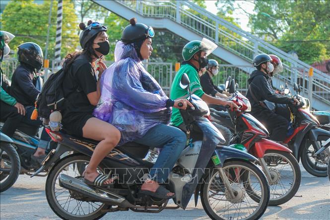 Người dân mặc áo mưa di chuyển từ hướng Hà Nam về Hà Nội. Ảnh: Hoàng Hiếu - TTXVN