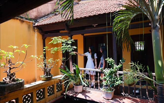 Visitors pose for photos at the ancient house at 87 Ma May street. VNA Photo