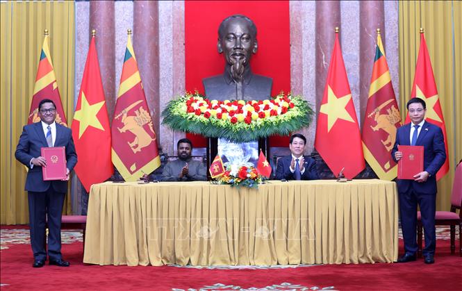 State President Luong Cuong and Sri Lankan President Anura Kumara Dissanayake witness the signing of an agreement between the two governments on cooperation and mutual assistance in the field of customs. VNA Photo: Lâm Khánh