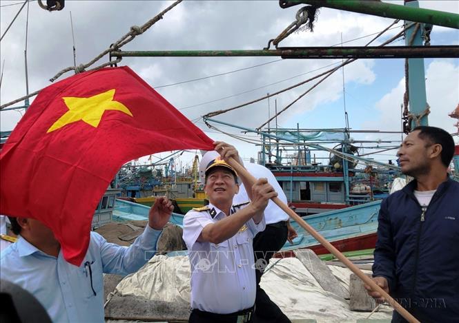 Đại tá Nguyễn Đình Hùng, Tư lệnh Vùng 4 Hải quân tặng cờ Tổ quốc cho ngư dân Bình Định trong chương trình “Hải quân Việt Nam làm điểm tựa cho ngư dân vươn khơi, bám biển” năm 2020. Ảnh: Nguyên Linh - TTXVN