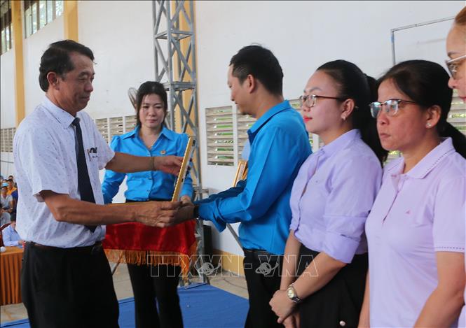 Tặng Bằng khen của Chủ tịch UBND tỉnh cho công nhân đạt thành tích xuất sắc trong lao động sản xuất. Ảnh: Tuấn Phi-TTXVN