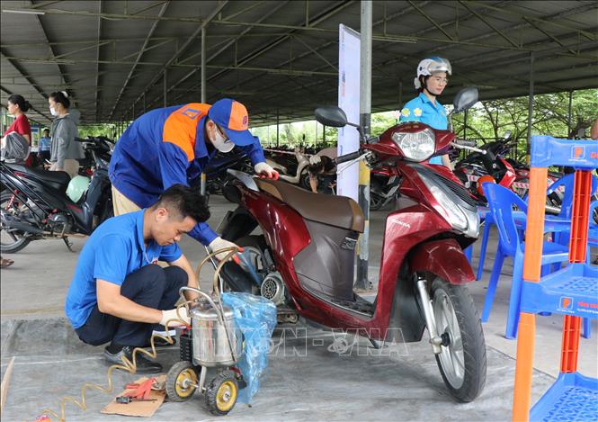 Thay dầu xe miễn phí cho người lao động. Ảnh: Thái Hùng - TTXVN
