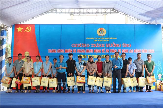 Ban tổ chức trao quà cho người lao động có hoàn cảnh khó khăn. Ảnh: Thái Hùng - TTXVN