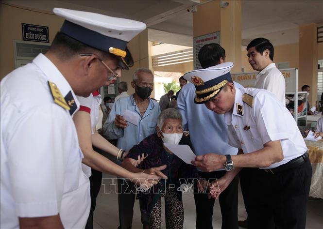 Chuẩn đô đốc Nguyễn Anh Tuấn, Tư lệnh Vùng 4 Hải quân hướng dẫn người dân lấy thuốc sau khi khám bệnh tại đơn vị y tế Hải quân. Ảnh: TTXVN phát