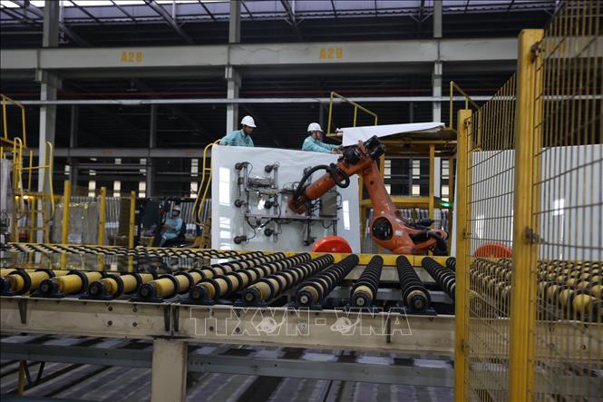 Robot di dời các tấm kính lên kệ tại dây chuyền sản xuất của Công ty TNHH Kính nổi siêu trắng Phú Mỹ (Tổng công ty Viglacera – CTCP) ở Khu công nghiệp Phú Mỹ II mở rộng. Ảnh: Hoàng Nhị - TTXVN 
