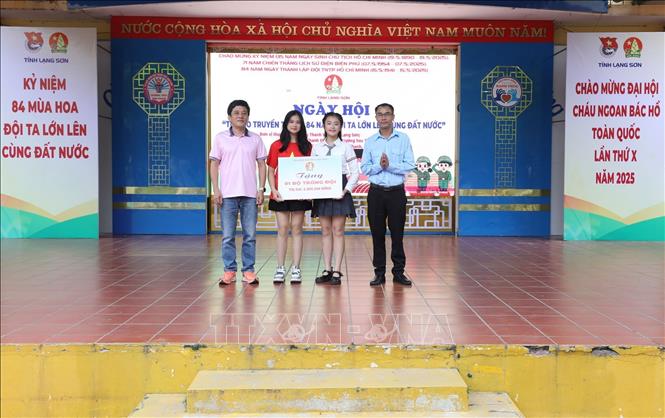 Phó Chủ tịch Hội đồng Đội tỉnh, Giám đốc Cung Thanh thiếu nhi Lạng Sơn Đỗ Văn Sơn (bên phải) tặng quà Trường THCS Tam Thanh tại Chương trình. Ảnh: Anh Tuấn – TTXVN