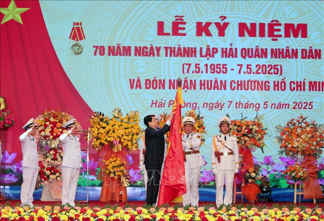 Chủ tịch nước Lương Cường gắn Huân chương Hồ Chí Minh lên lá cờ Quyết thắng của Hải quân nhân dân Việt Nam. Ảnh: Trọng Đức - TTXVN