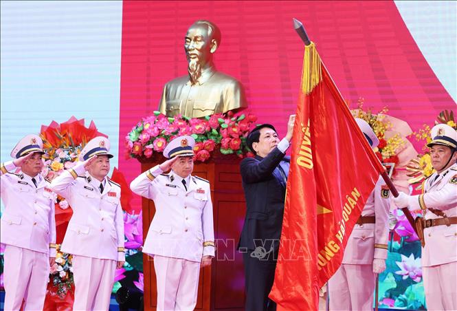 Chủ tịch nước Lương Cường gắn Huân chương Hồ Chí Minh lên lá cờ Quyết thắng của Hải quân nhân dân Việt Nam. Ảnh: Lâm Khánh - TTXVN
