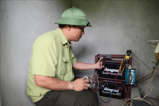 Lực lượng Kiểm lâm kiểm tra hệ thống pin tích điện tại trạm camera giám sát bảo vệ rừng. Ảnh: Hoa Mai - TTXVN