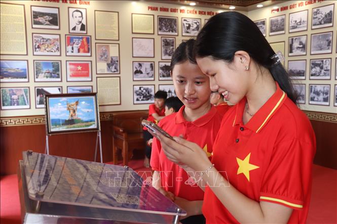 Học sinh quét mã QR tìm hiểu về Anh hùng liệt sĩ Phan Đình Giót và Chiến dịch lịch sử Điện Biên Phủ. Ảnh: Hoàng Ngà - TTXVN